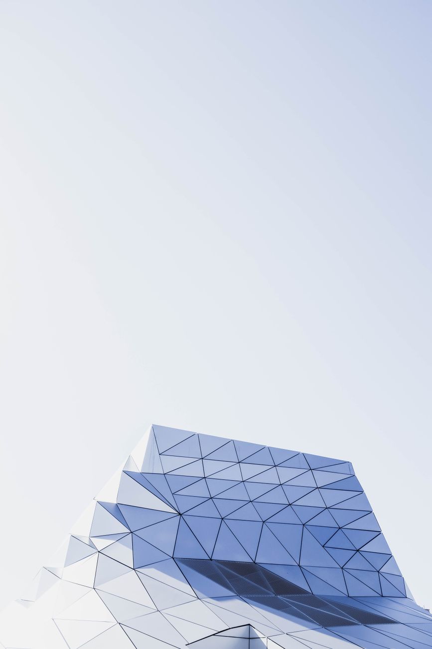Striking modern building with geometric facade against clear sky.