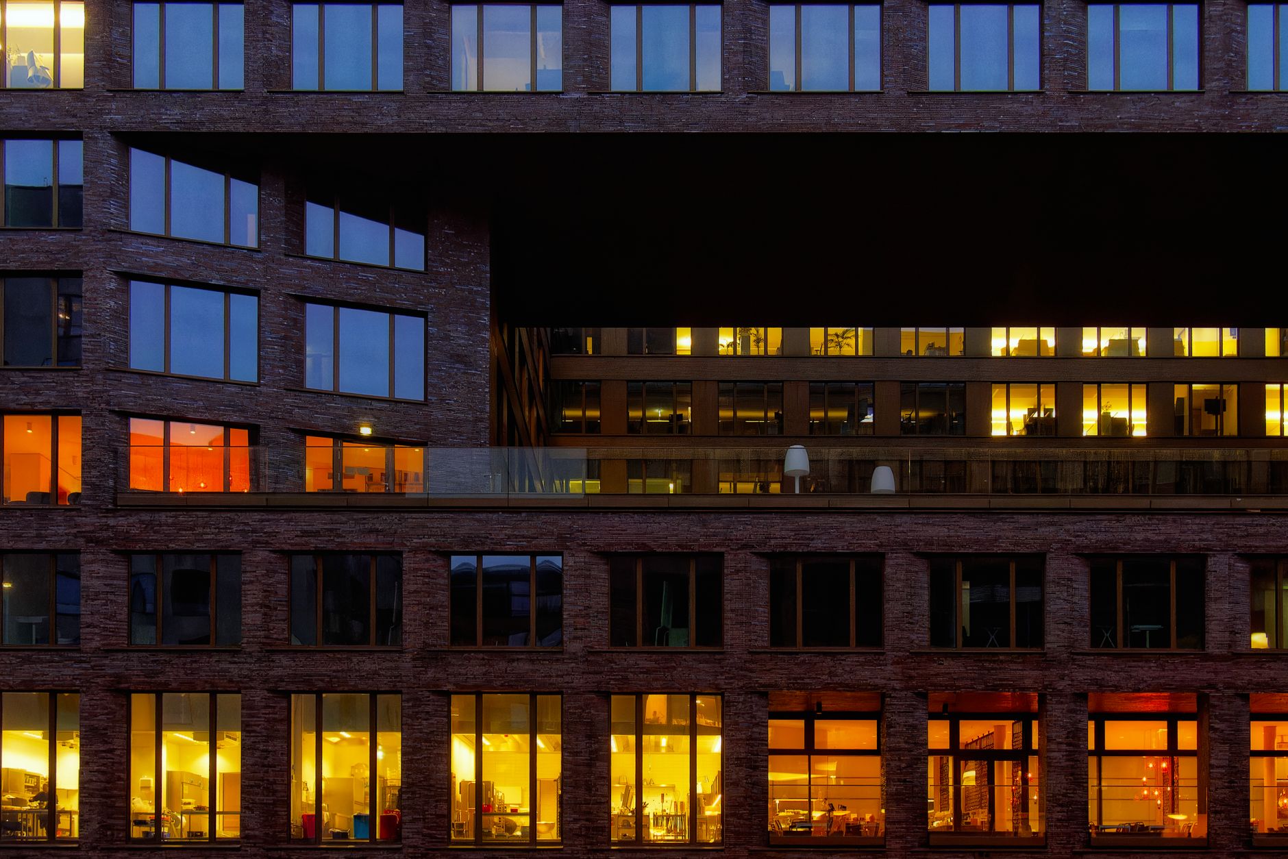 Close-up view of an illuminated office building exterior at night, showcasing modern architecture.