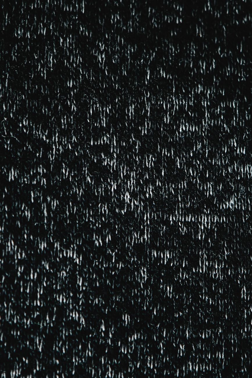 Close-up of a textured dark fabric surface, ideal for use as a background or wallpaper.