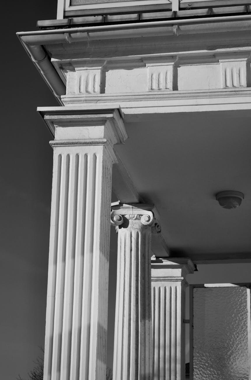 Monochrome image of Greek-style Ionic columns on a building facade.