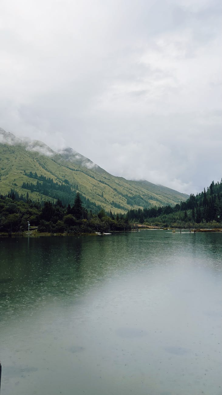 Tranquil lake and misty mountains in Ngawa Prefecture, China.