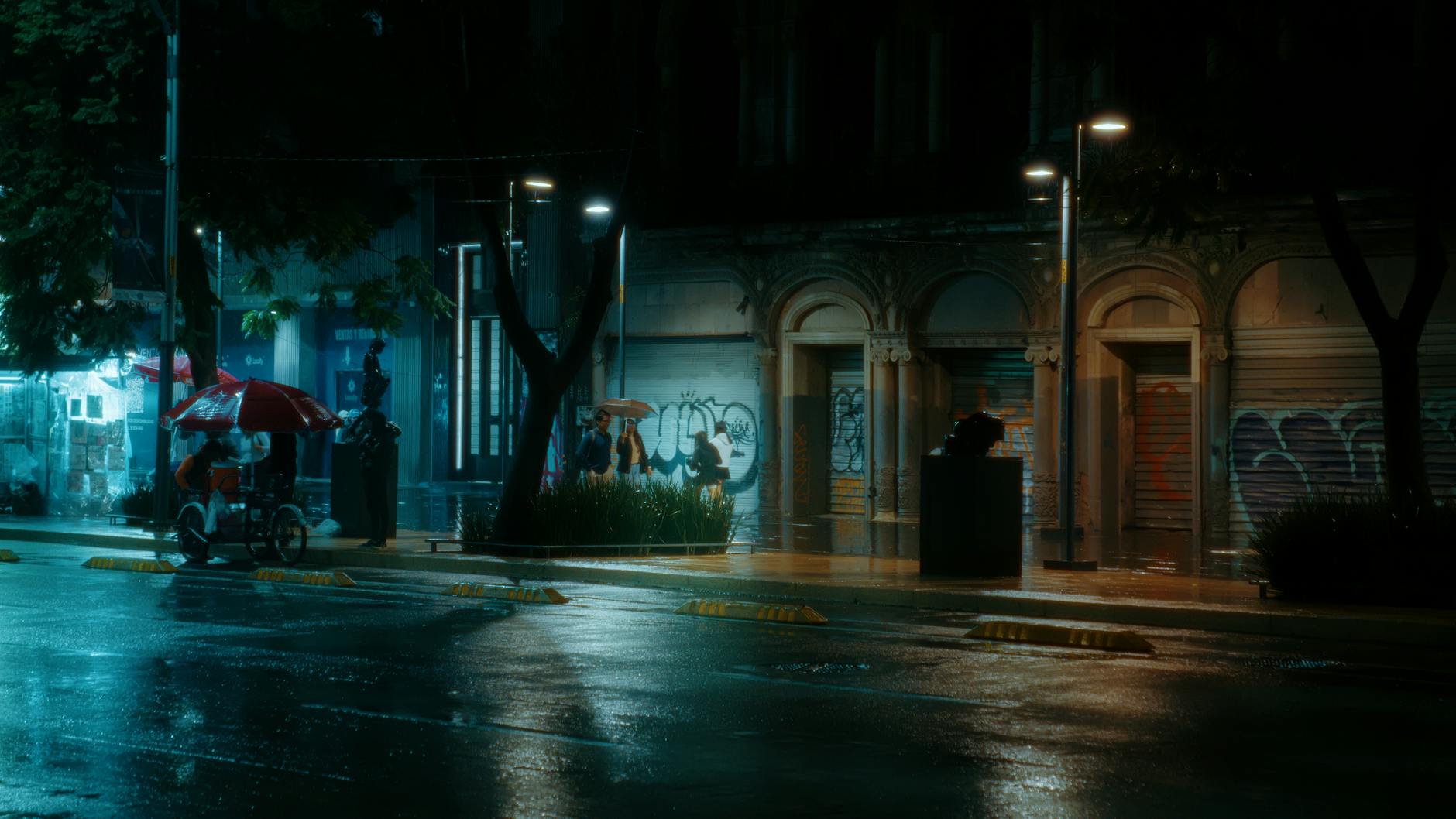 Quiet rainy night in Mexico City with people under umbrellas on a dimly lit street.