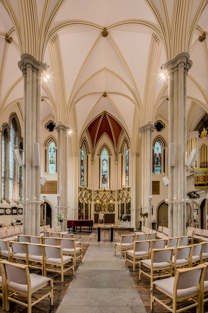 Stunning Gothic church interior with stained glass and arches in England.