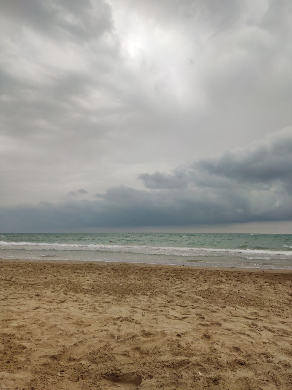 Scenic view of Marotta Beach with cloudy skies and gentle waves in Marche, Italy.