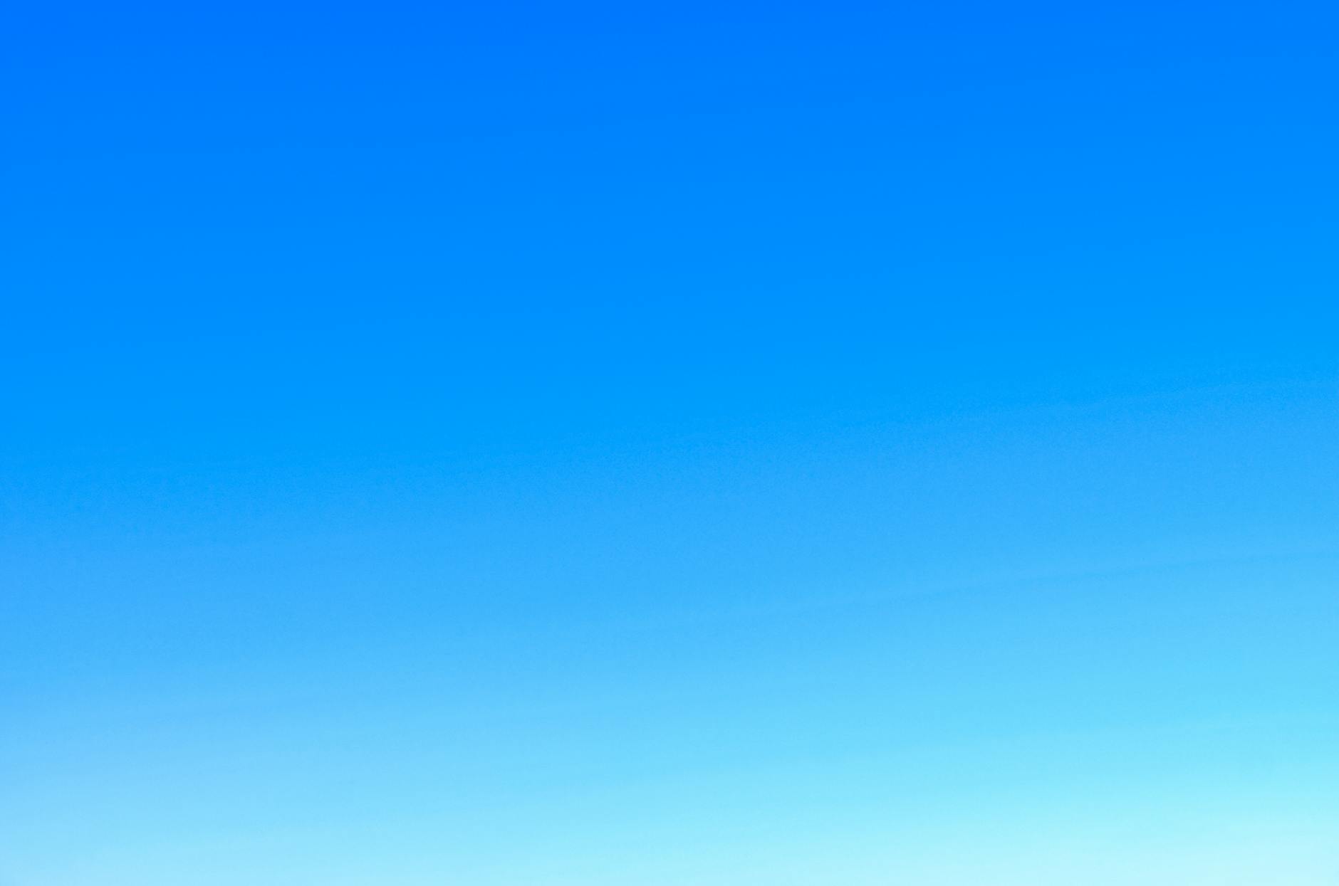 A serene view of a vibrant clear blue sky with a subtle gradient, perfect for backgrounds.