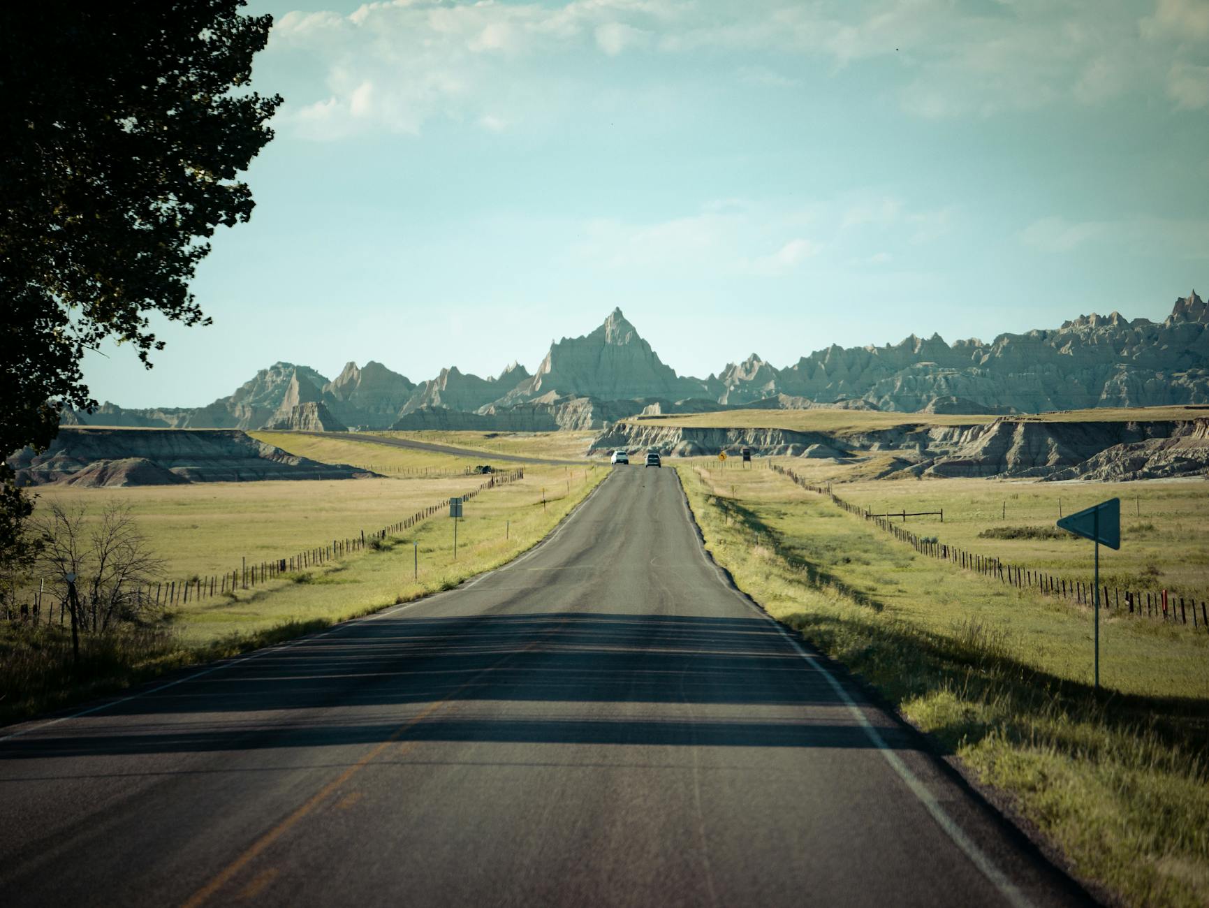 A scenic road stretching through the Badlands landscape under a clear sky.