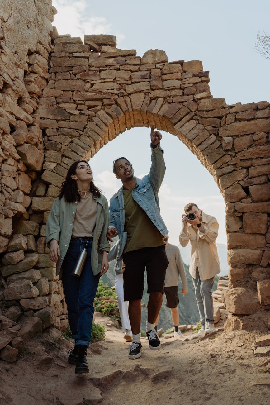 Group of tourists exploring ancient stone ruins with a photographer capturing the moment.