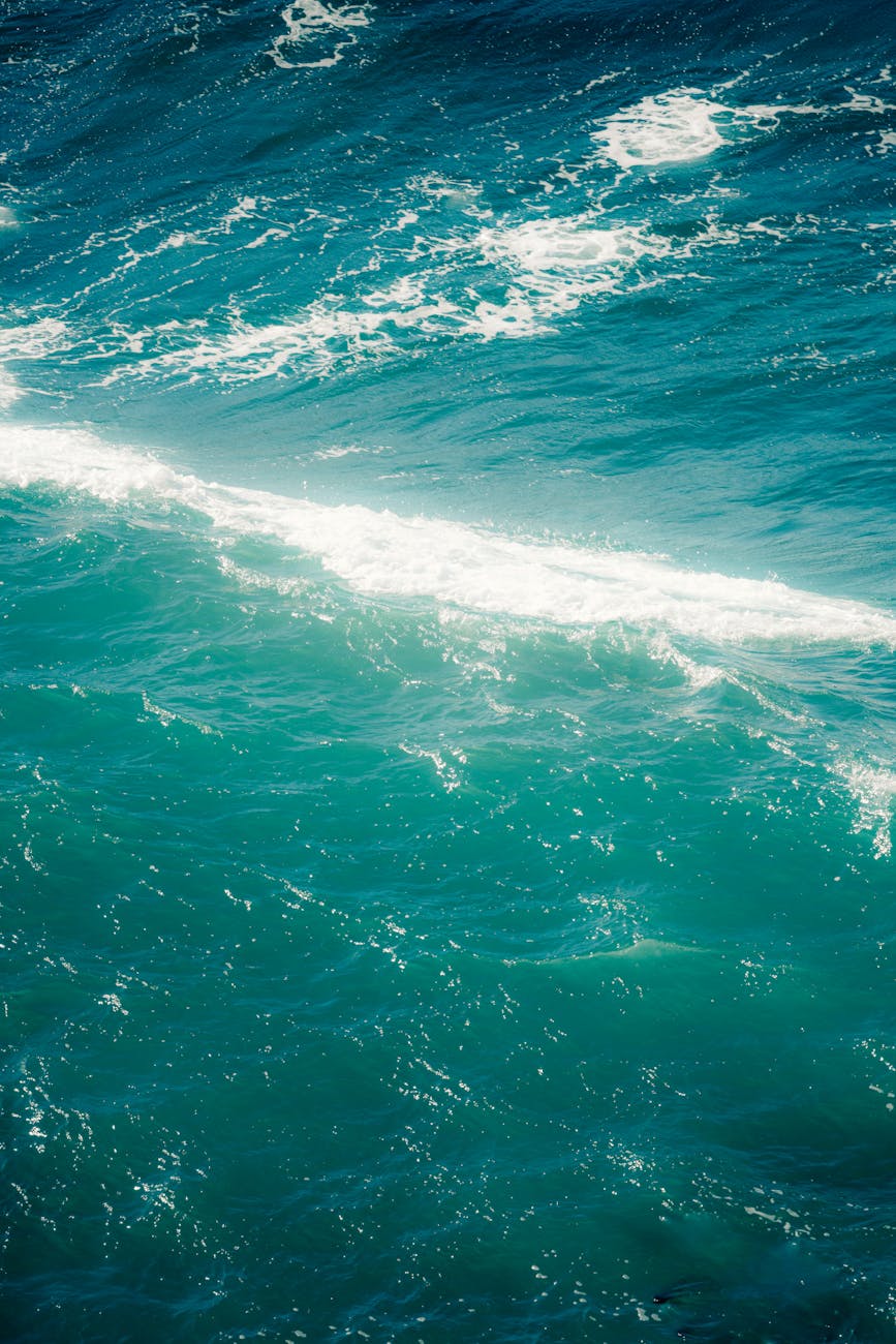 Captivating view of vibrant turquoise ocean waves with white foam, showcasing natural beauty.
