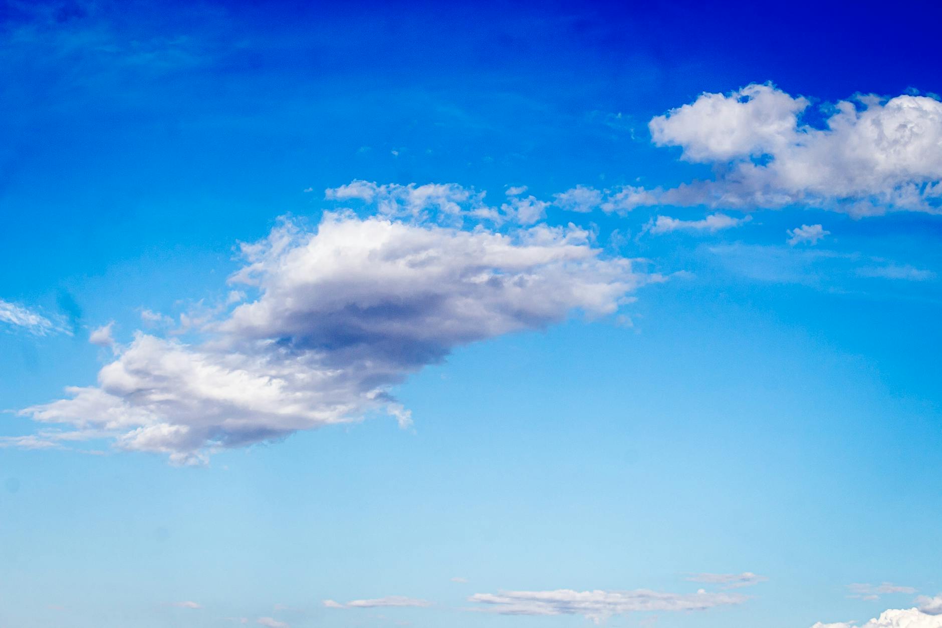 A serene blue sky with scattered white clouds creating a tranquil and airy atmosphere.