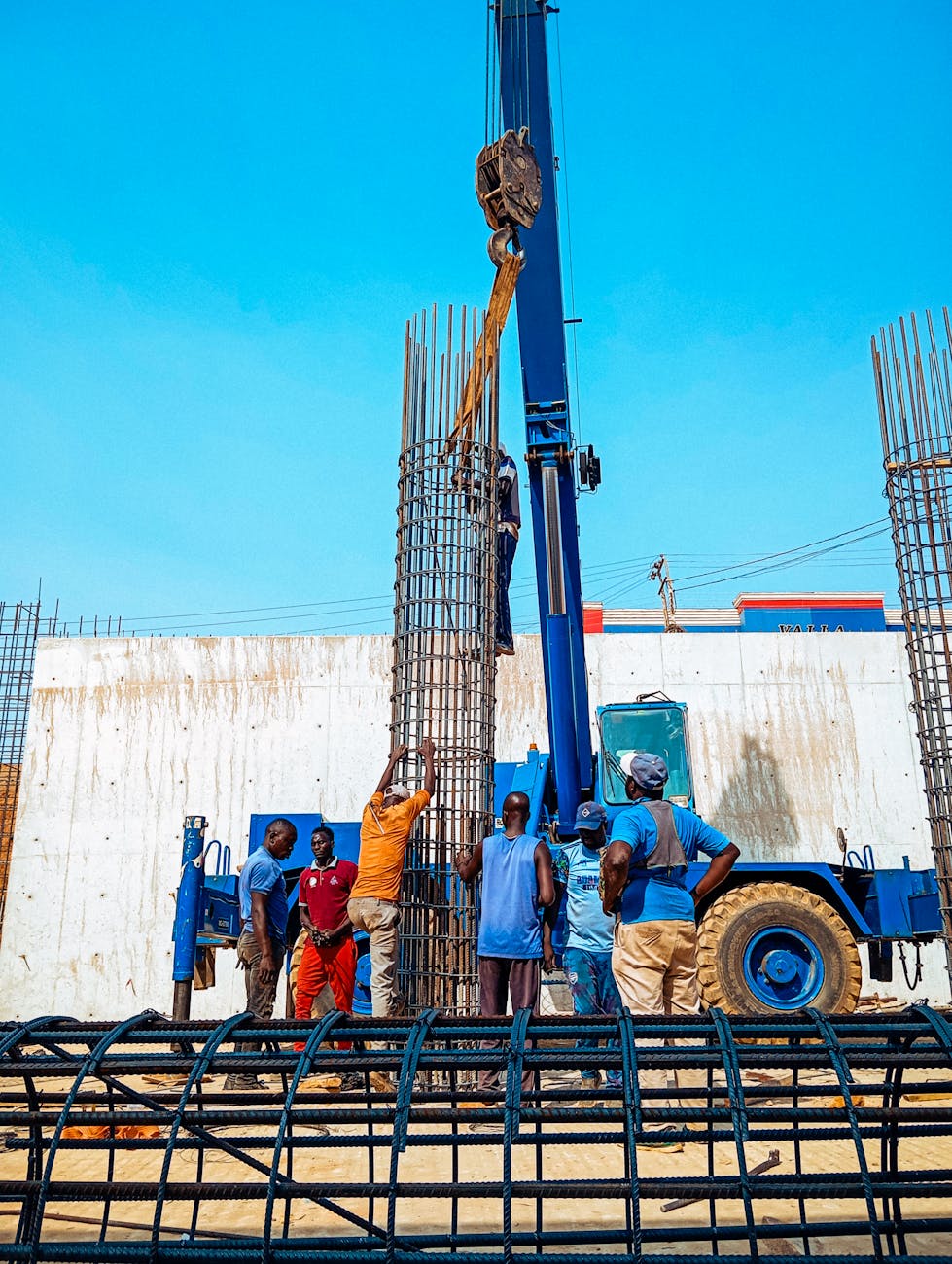 Construction workers in Jimeta, Nigeria erecting rebar columns for a building project.