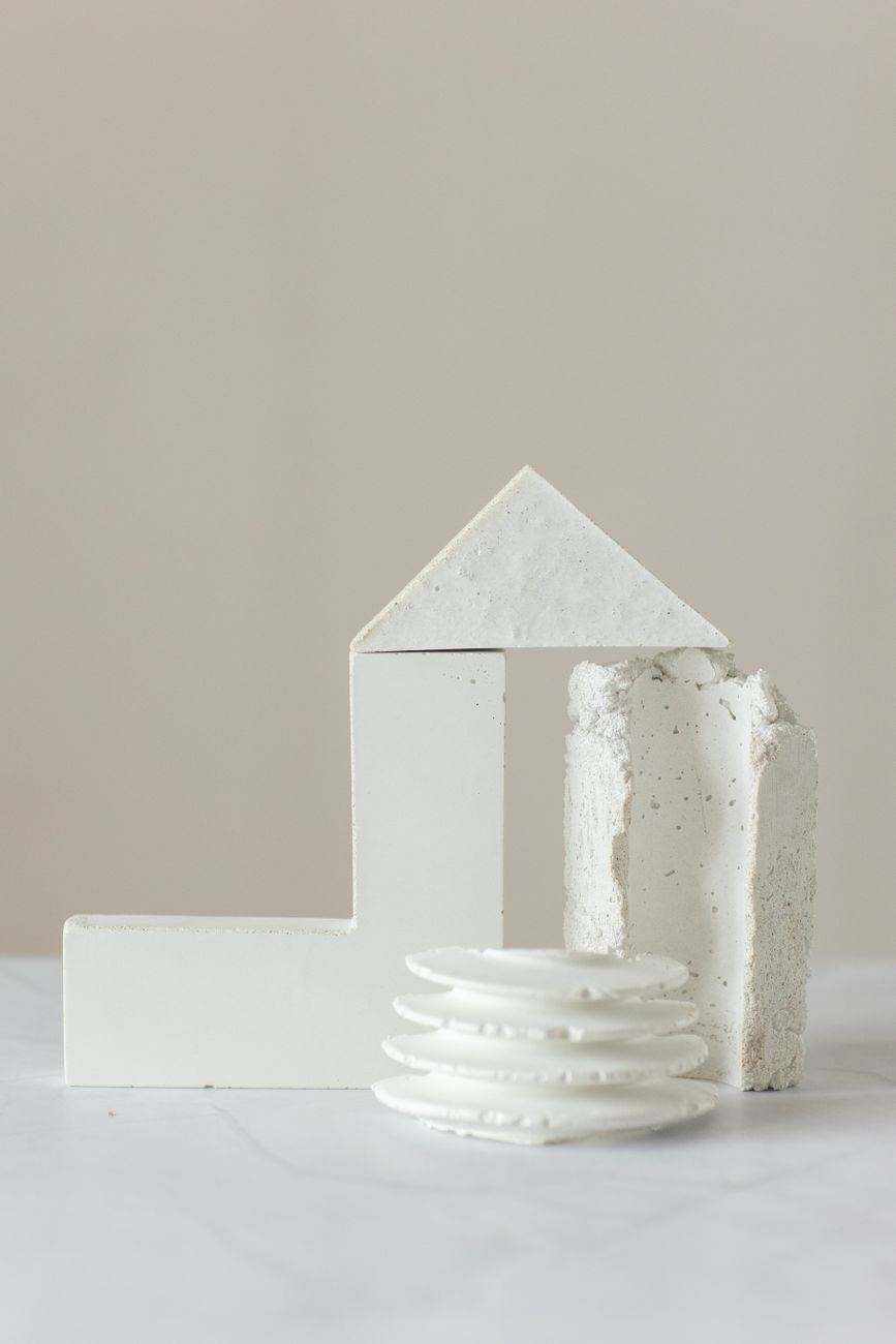 A minimalist arrangement of geometric white shapes on a neutral background.