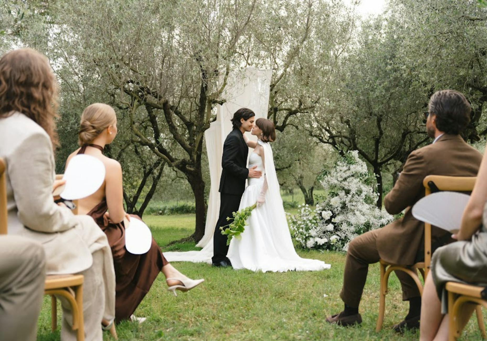 A beautiful outdoor wedding ceremony in Torroella de Montgrí, Spain with the couple and guests.