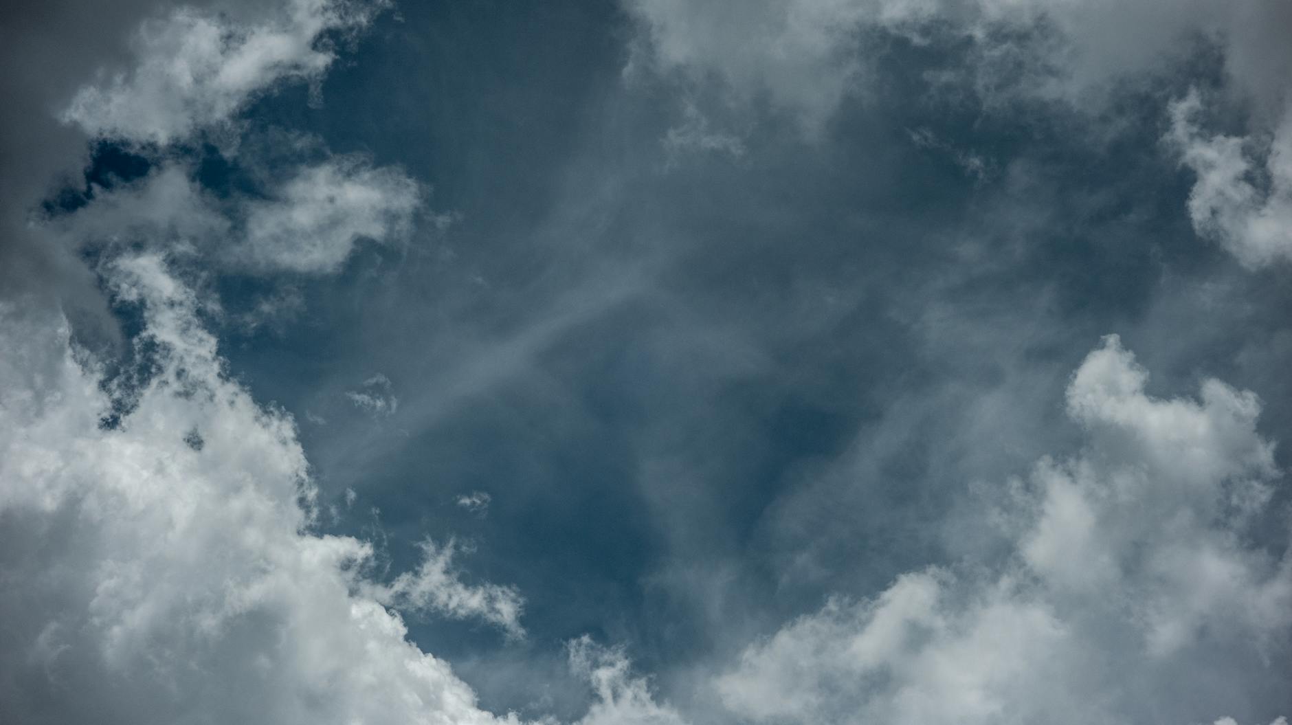 A mesmerizing view of a cloudy sky with dark blue tones and dramatic cloud formations.