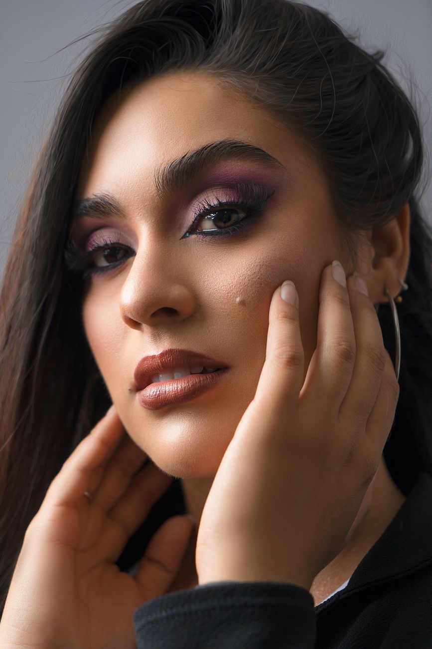 Close-up portrait of a woman with striking makeup and elegant expression.
