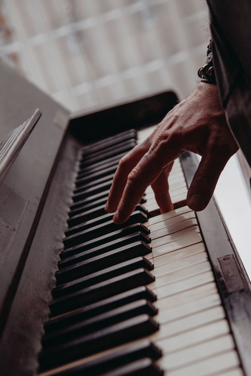 A close-up view of a hand playing piano keys, creating a musical moment.