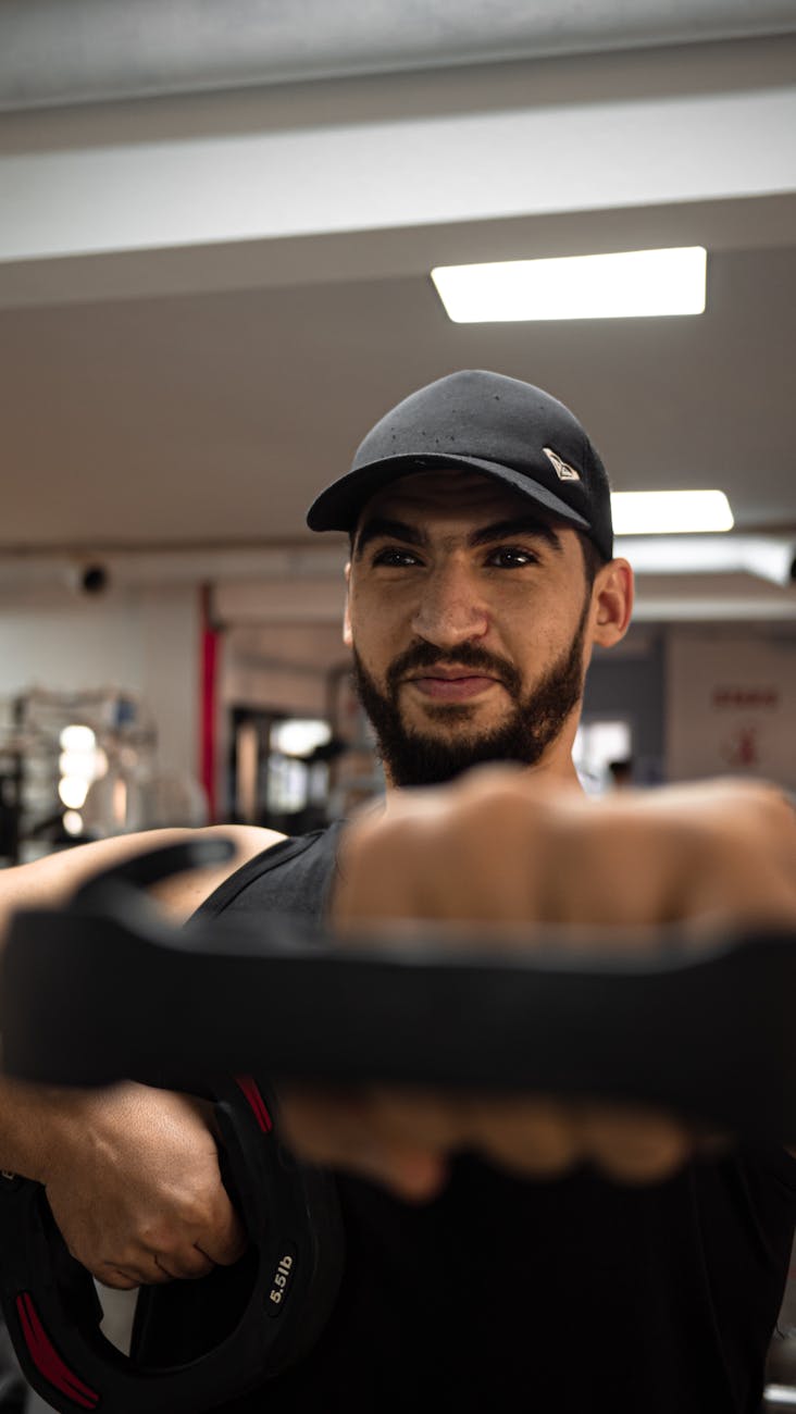 Bearded man lifting weights in a gym in Morocco. Focused on strength training.