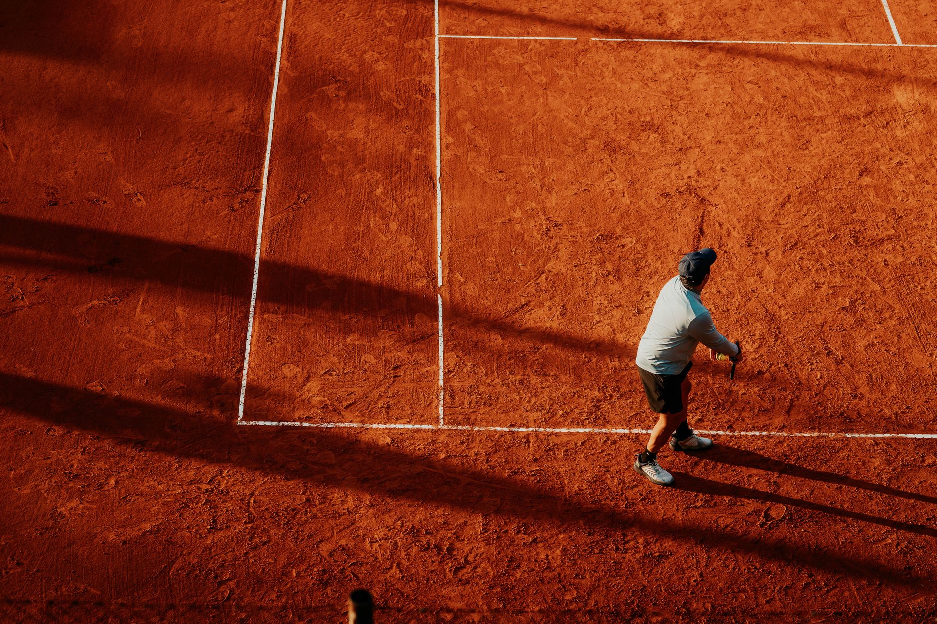 Overhead view of a tennis player on a clay court in Buenos Aires, Argentina. Vibrant and dynamic scene.