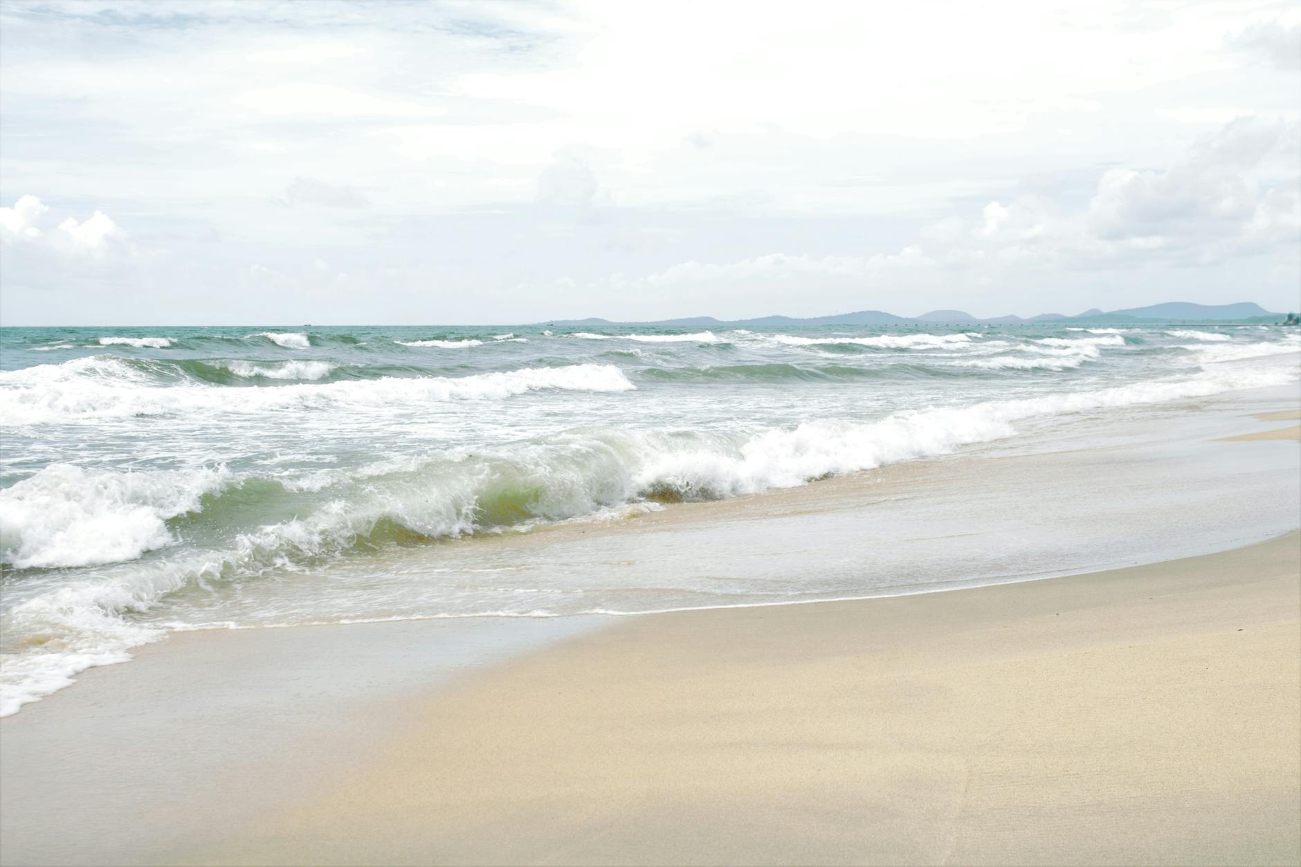 Peaceful seascape of a beach in Vietnam with gentle waves and soft sand.