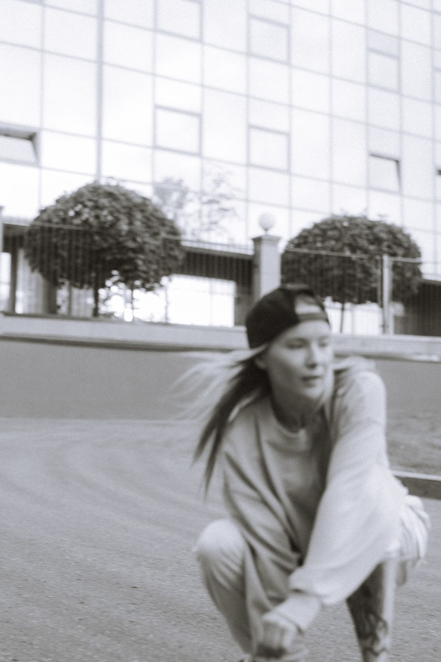 Black and white image of a young skater in action, capturing a modern urban feel.