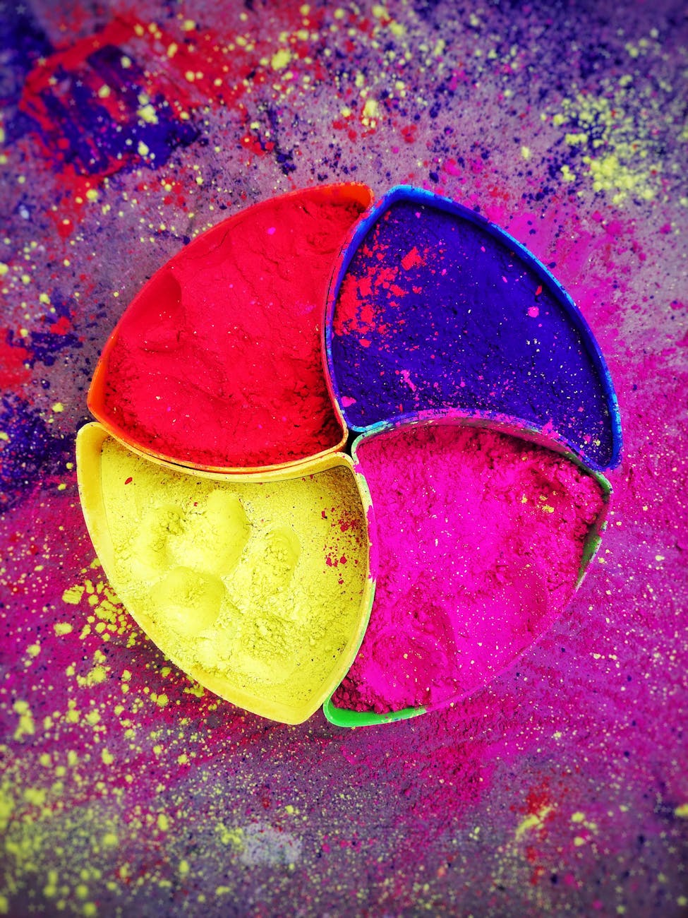 Vibrant Holi powder in colorful segmented dishes, perfect for festival and decoration themes.
