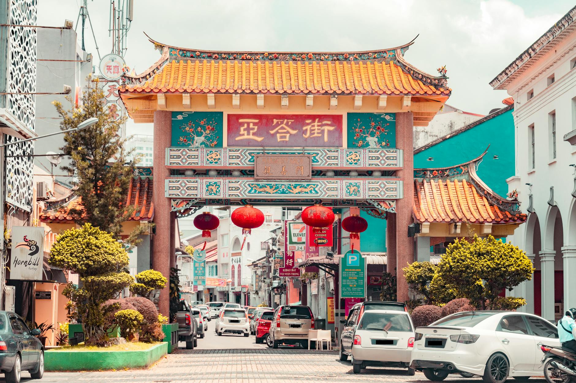 Bustling street scene featuring a traditional Chinese archway in a vibrant Asian city.