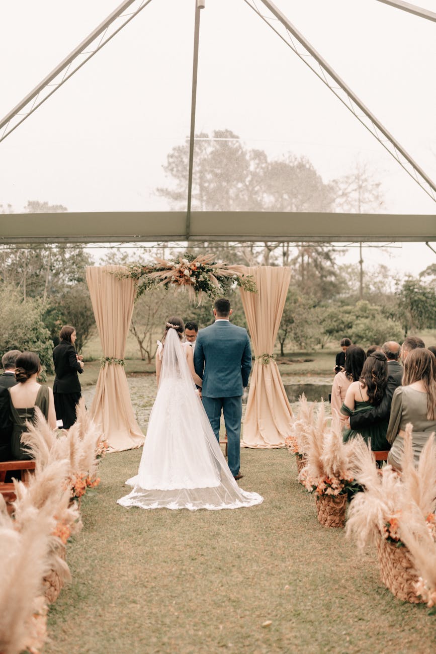 Elegant outdoor wedding ceremony with the bride and groom at the altar surrounded by guests.