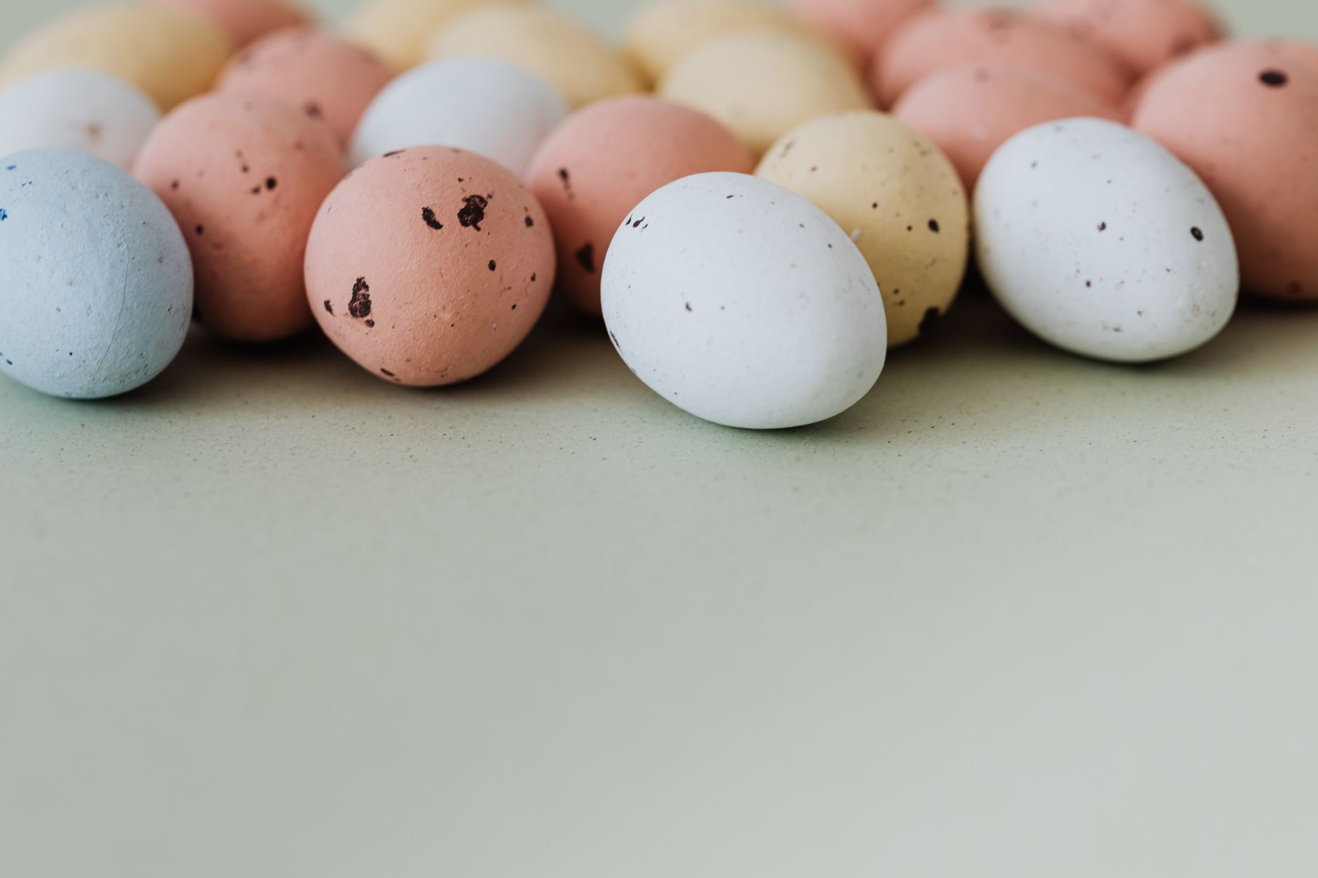 Vibrant speckled Easter eggs arranged on a pastel background, perfect for seasonal decor.