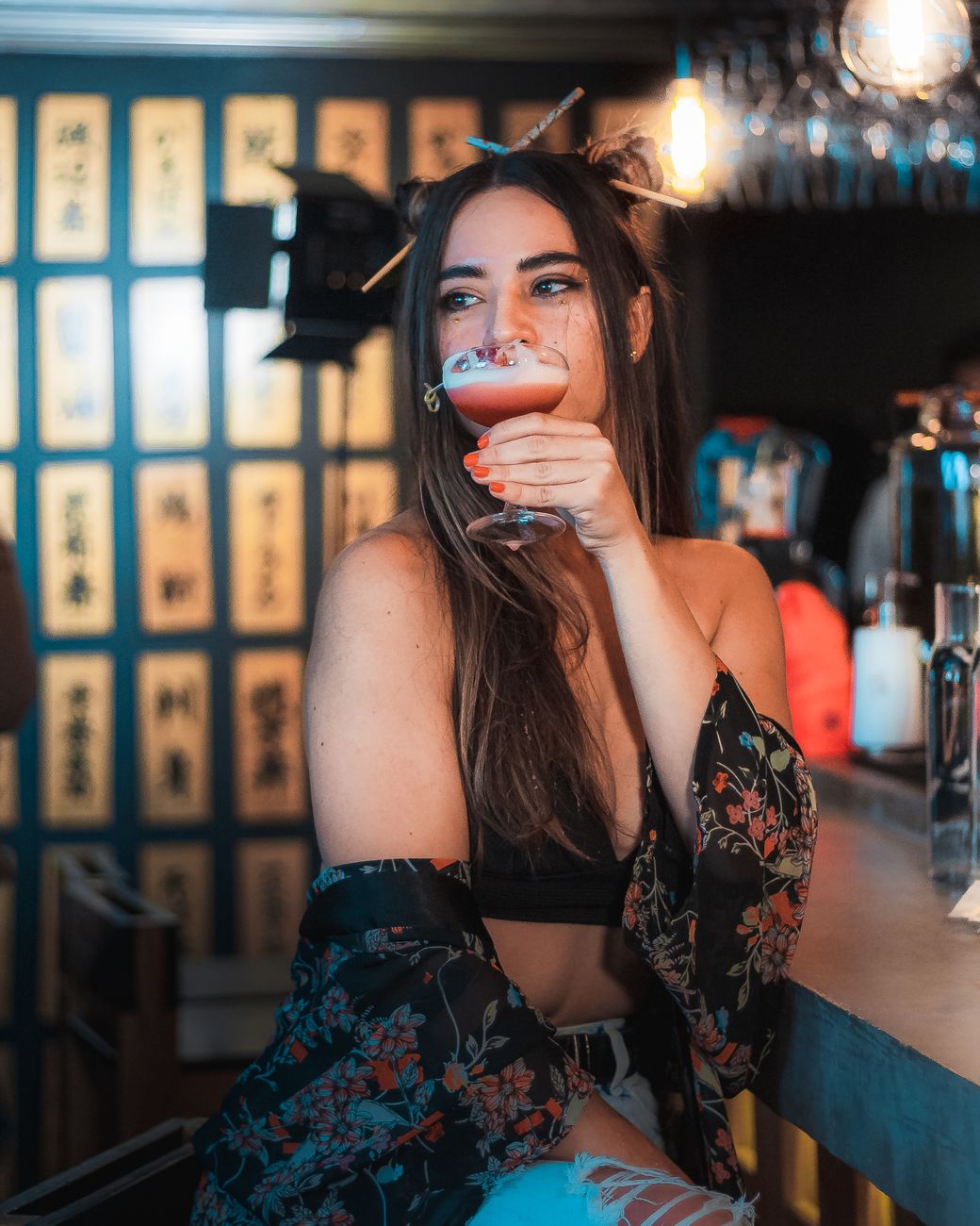 A fashionable woman sips a cocktail at a chic bar in Mexico City.