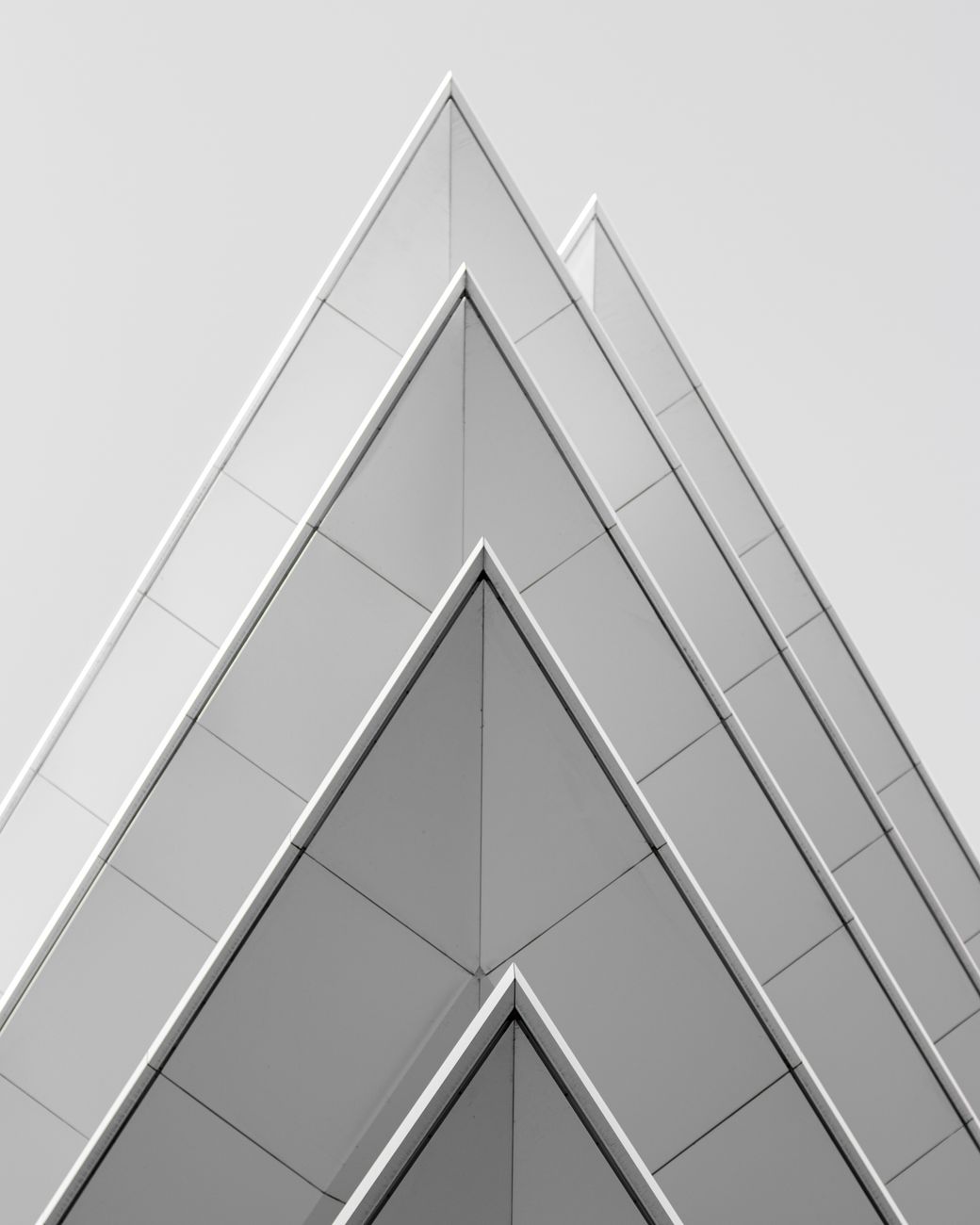 Futuristic pyramid-shaped building facade in Athens, Greece showcasing modern architectural design.