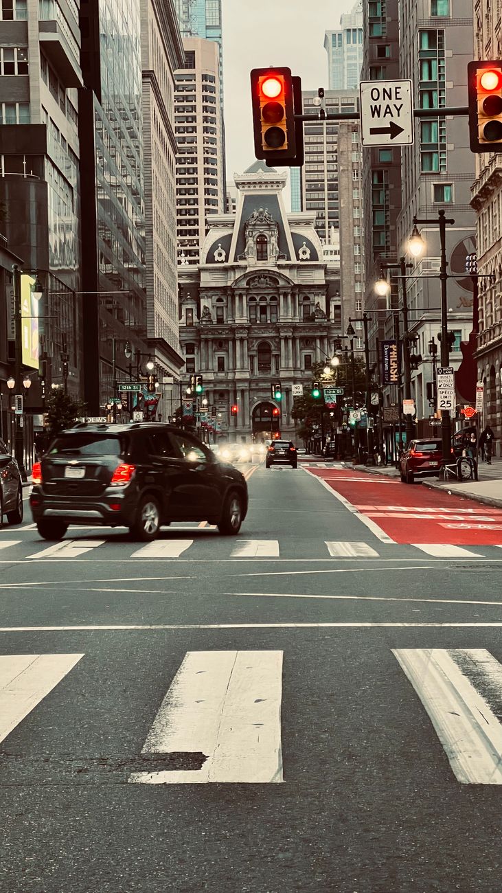 Dramatic view of Philadelphia City Hall amidst urban traffic and city life.