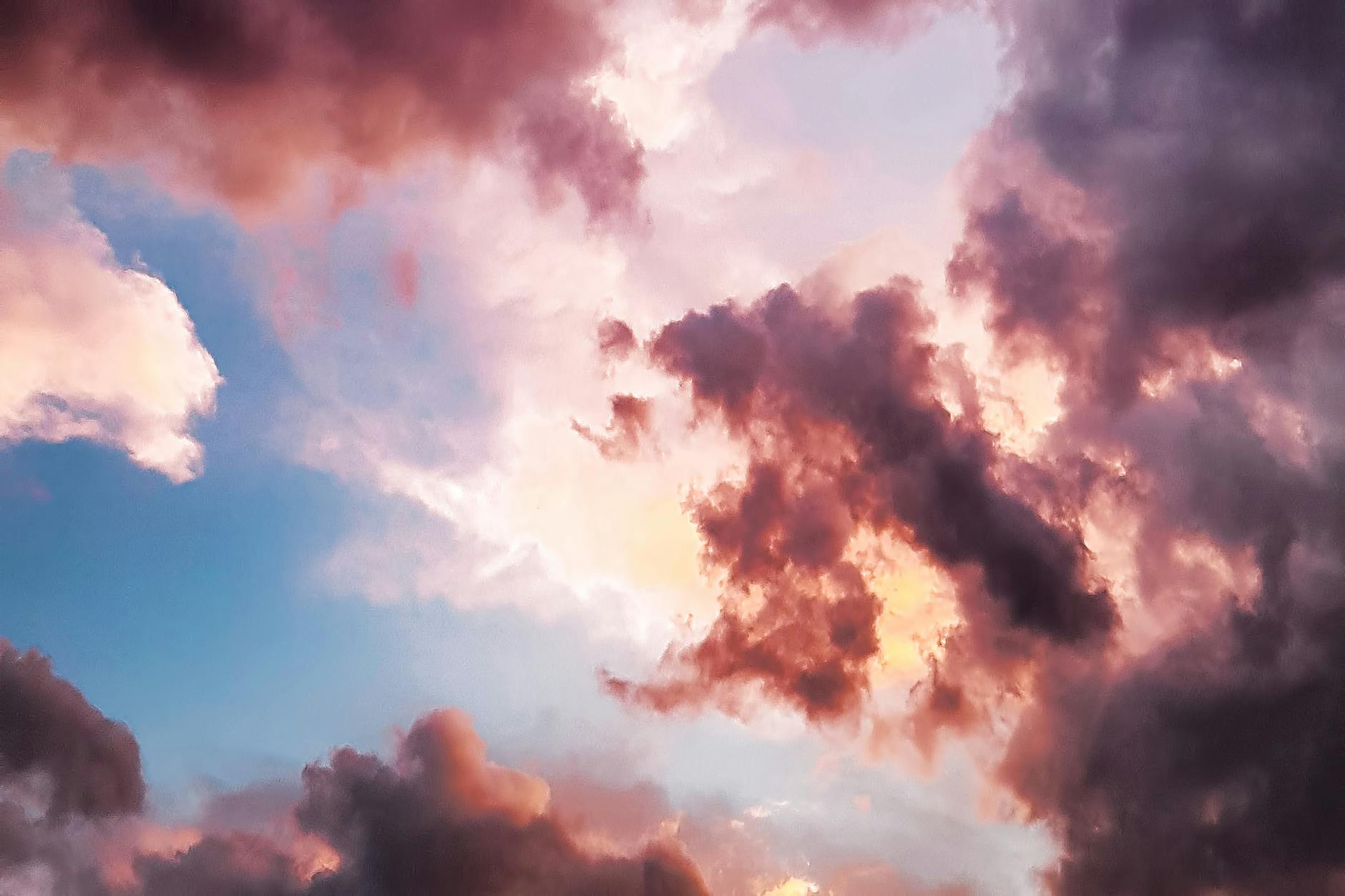A vibrant and dreamy sky with pink and orange clouds during a sunset, showcasing nature's beauty.