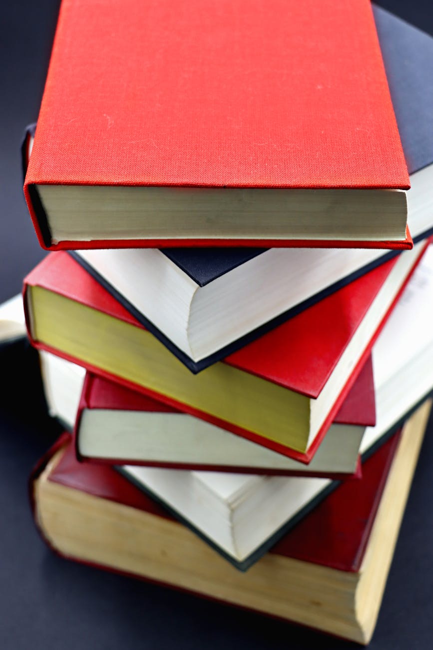 A diverse stack of hardcover books with red and black covers, perfect for education-themed projects.