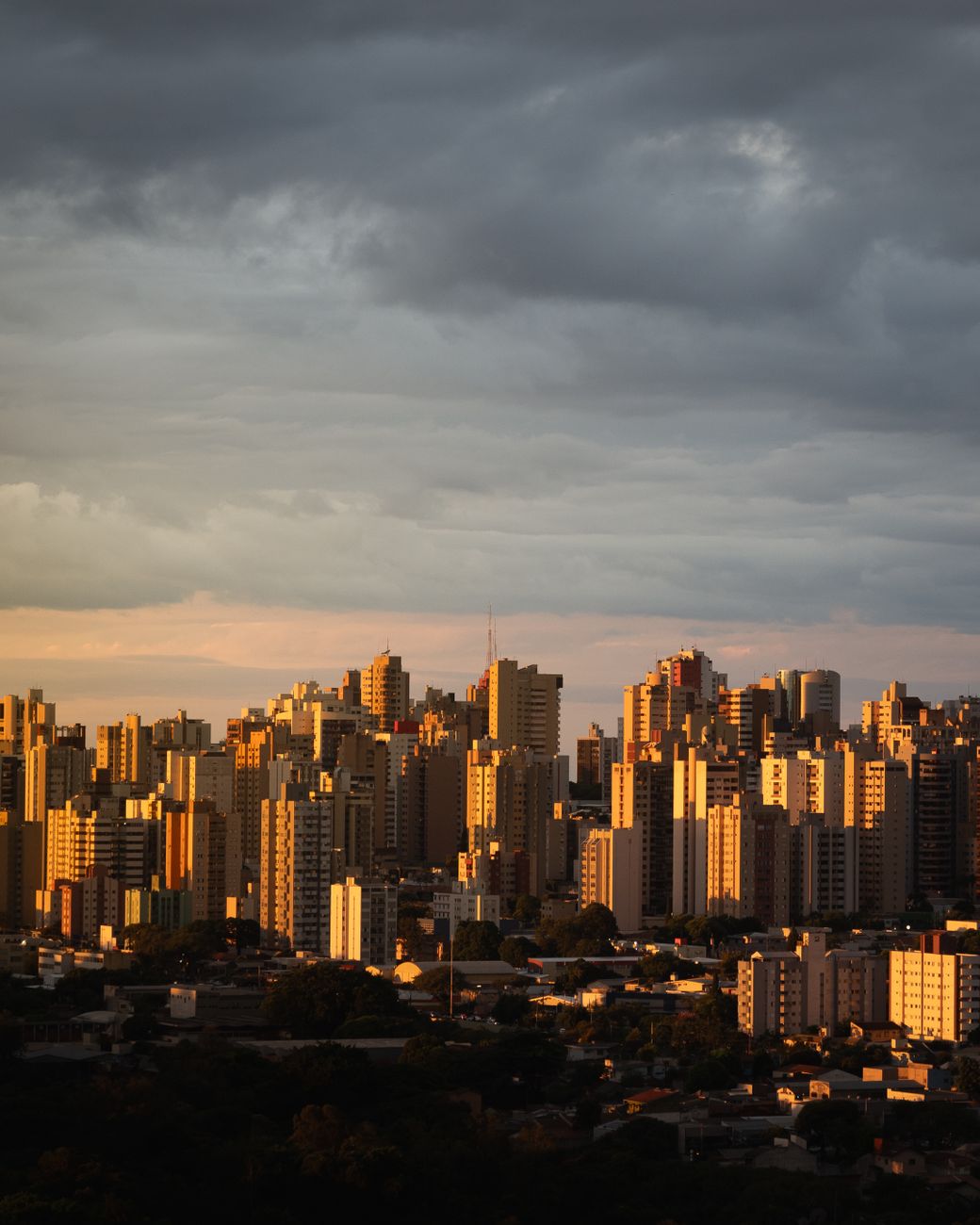 Vibrant cityscape at twilight with a dramatic sky, showcasing urban architecture.