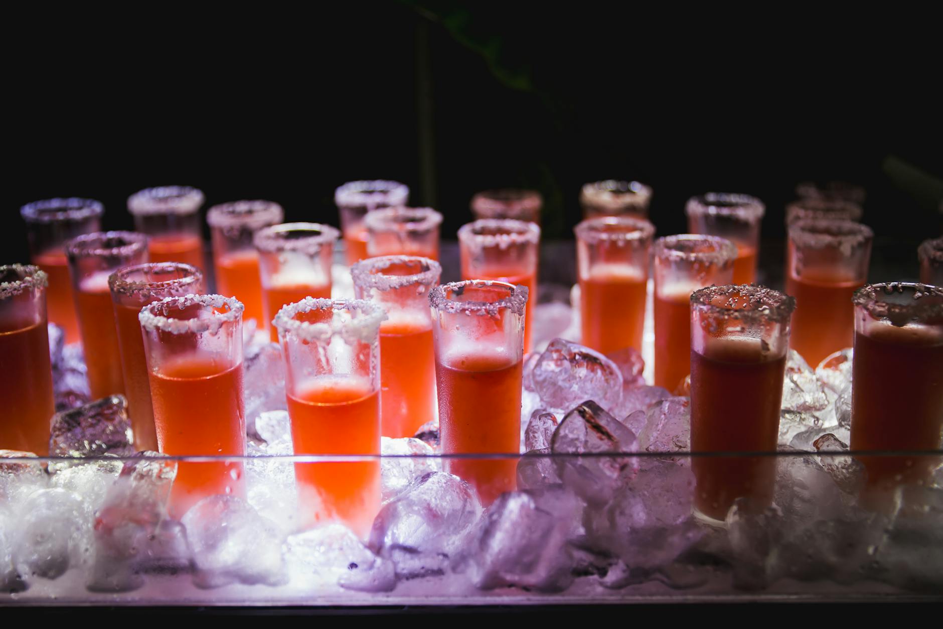 Vibrant display of red cocktails on ice, perfect for parties and events.
