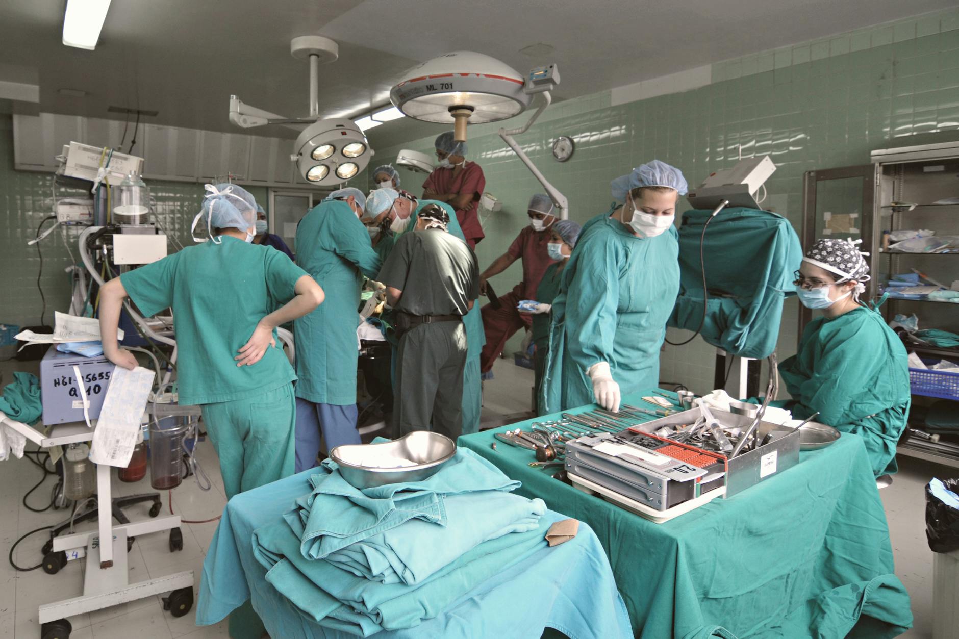A surgical team performs an operation in a hospital operating room.