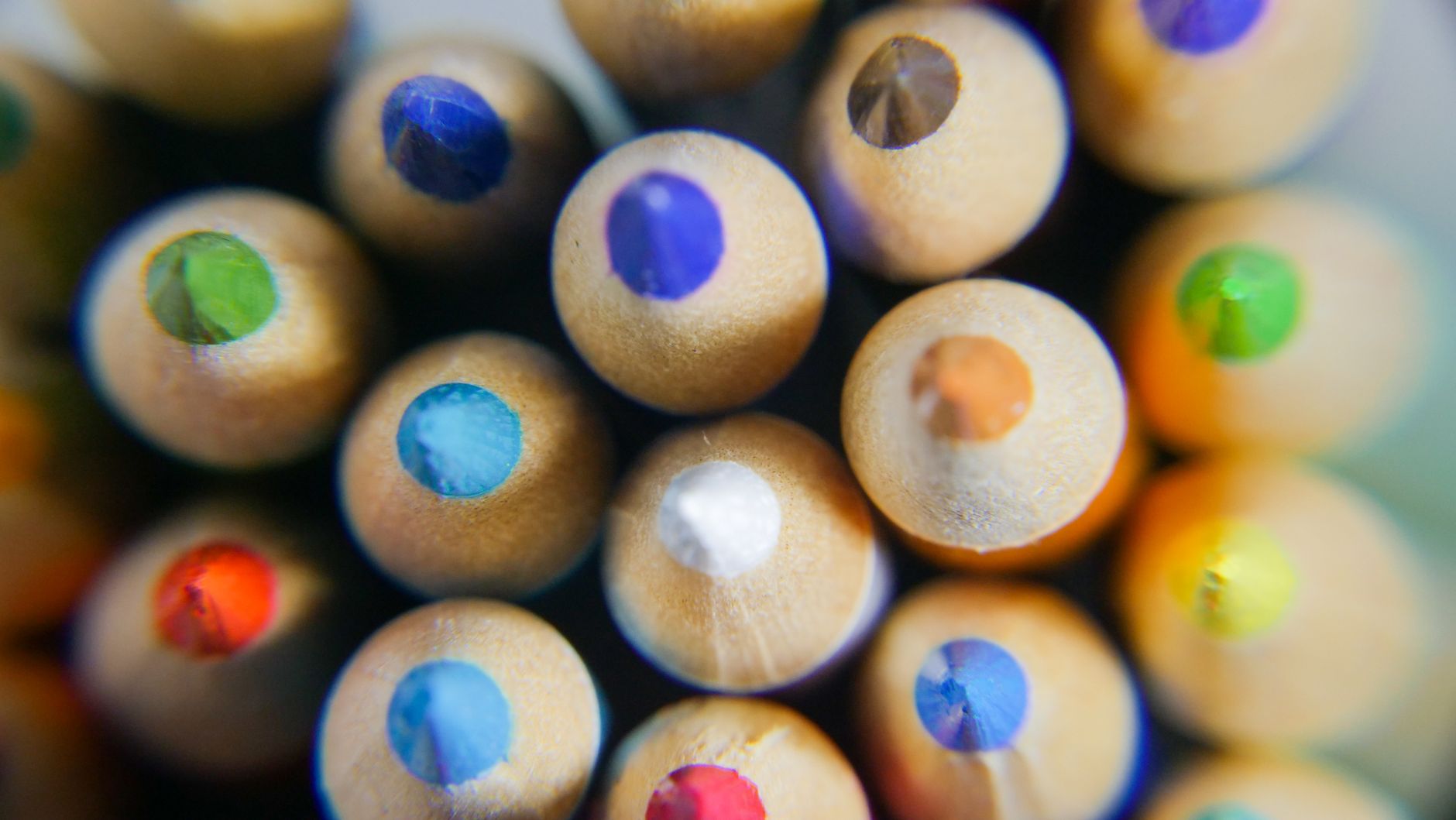 Close-up of vibrant colored pencils viewed from the top, showcasing sharpened tips.