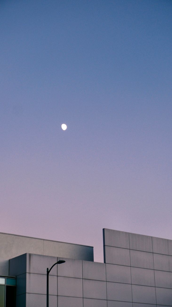 Minimalist modern architecture against a twilight sky with moon.