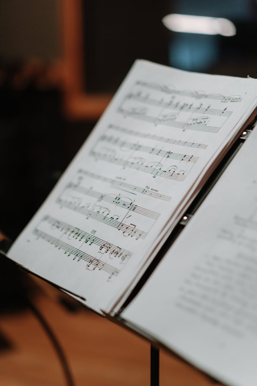 Detailed view of open sheet music in a music studio setting, emphasizing musical notes.
