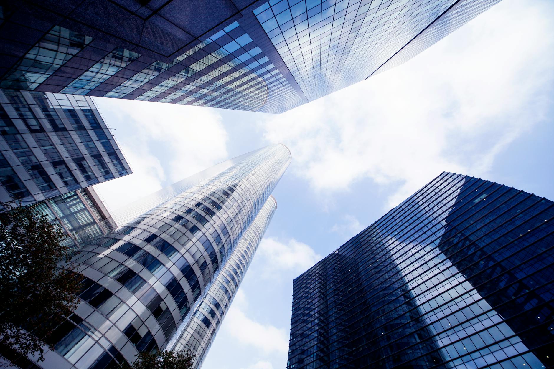 Upward view of innovative skyscrapers under a bright sky in La Défense, Paris.