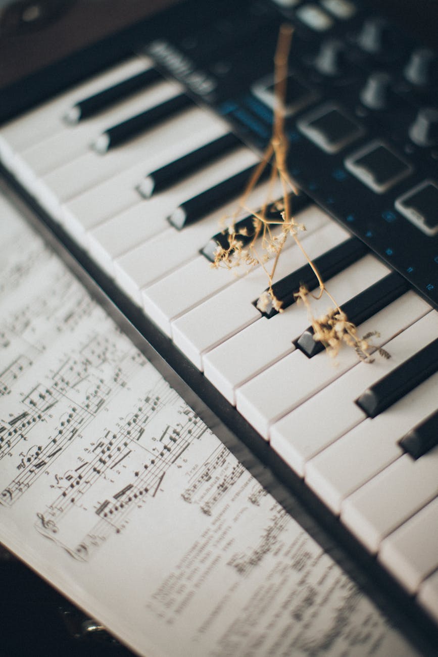 Close-up of piano keys with a flower and sheet music creates an artistic and musical ambiance.