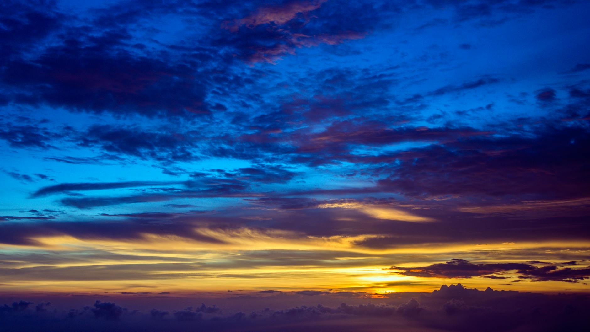 Stunning sunset with vibrant colors and dramatic cloud formations against a clear blue sky.