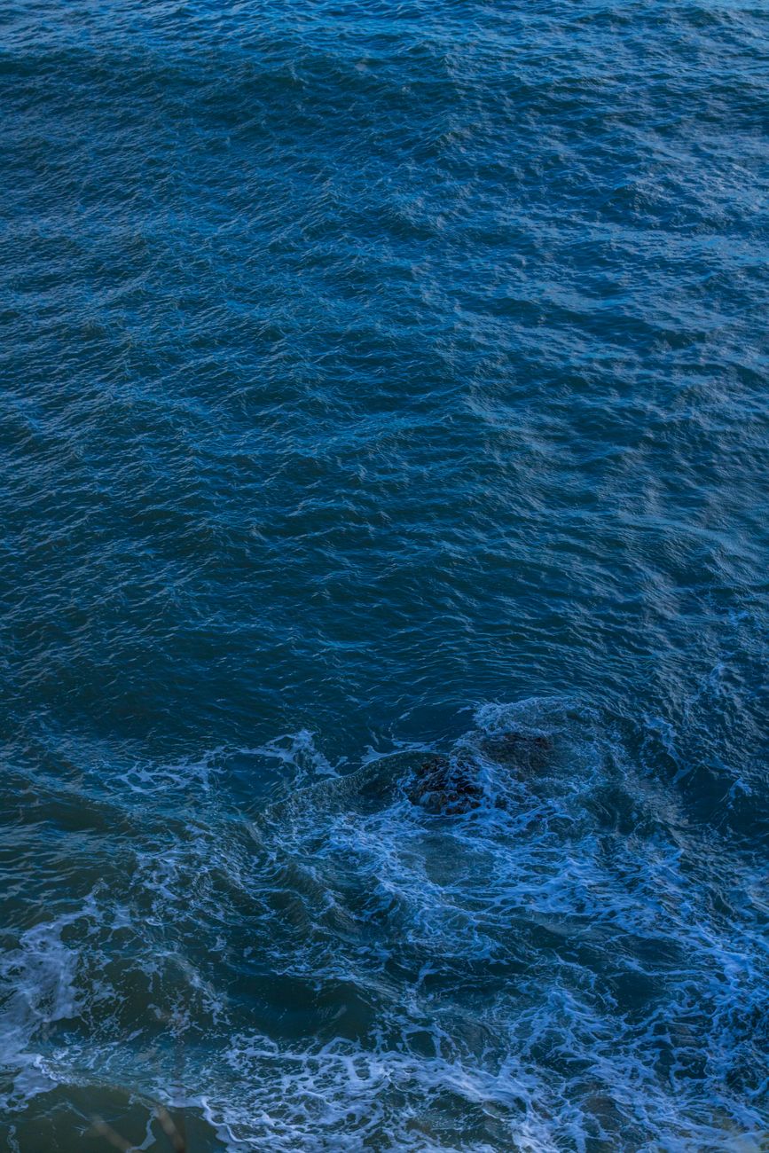 A tranquil view of ocean waves with deep blue tones and gentle motion.