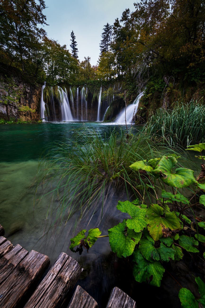 Capture of a serene waterfall in Plitvice Lakes, Croatia, with lush greenery.