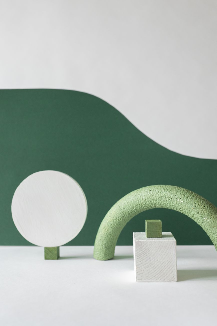 Minimalist composition of geometric shapes on a green and white backdrop, perfect for modern design concepts.