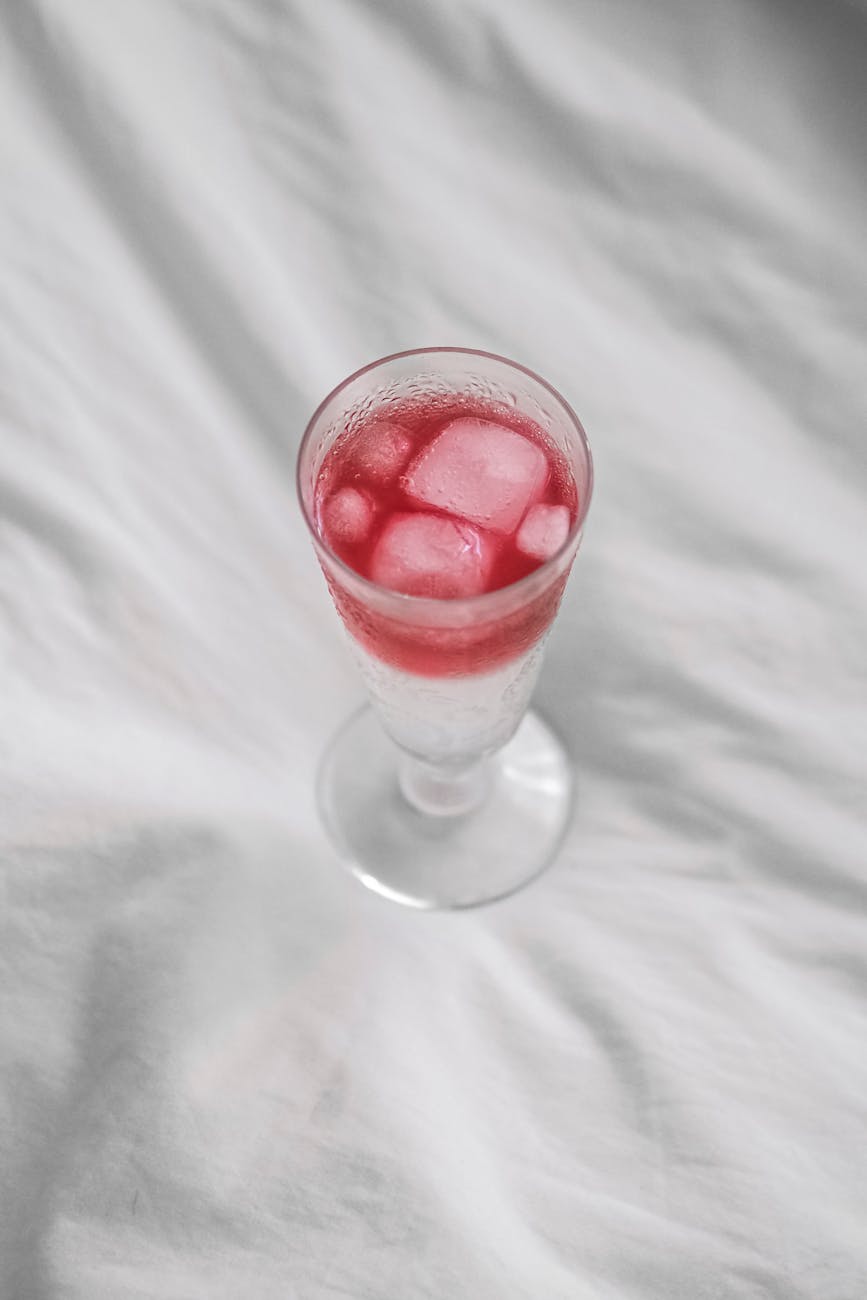 A vibrant summer berry cooler with ice in a clear glass, perfect for hot days.