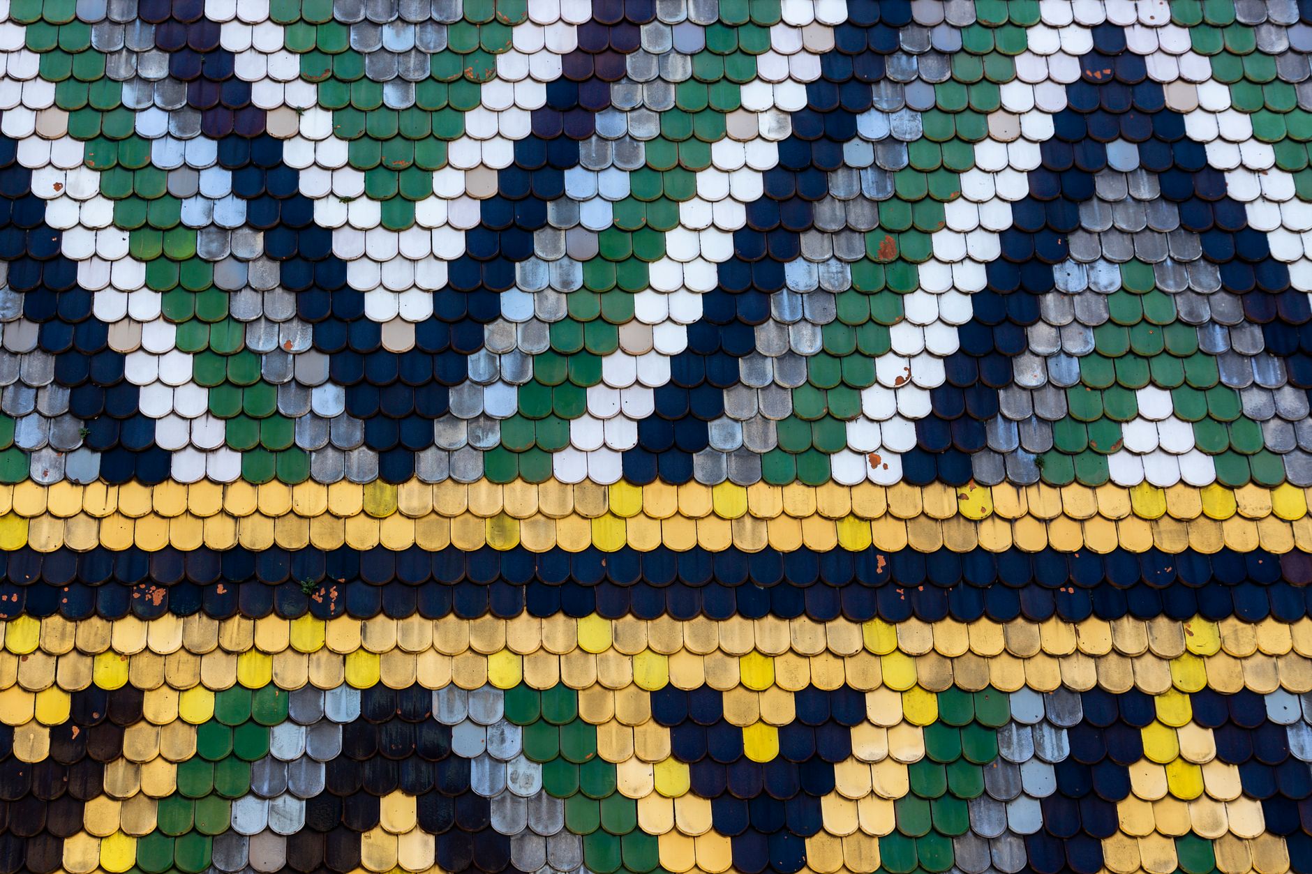Vibrant geometric pattern of colored tiles on a roof showcasing artistic detail.