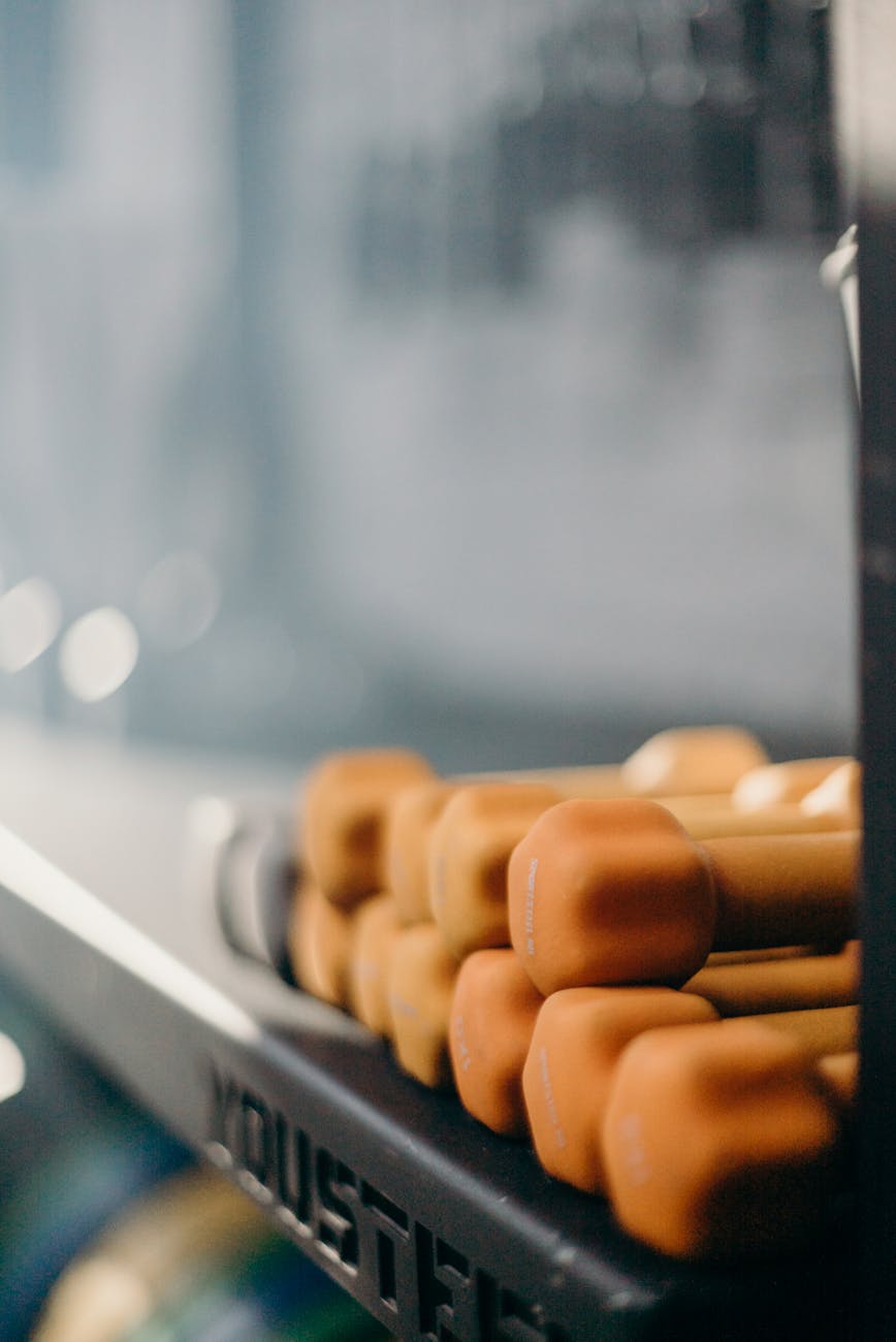 Stacked orange dumbbells on a gym rack, perfect for fitness and workout themes.