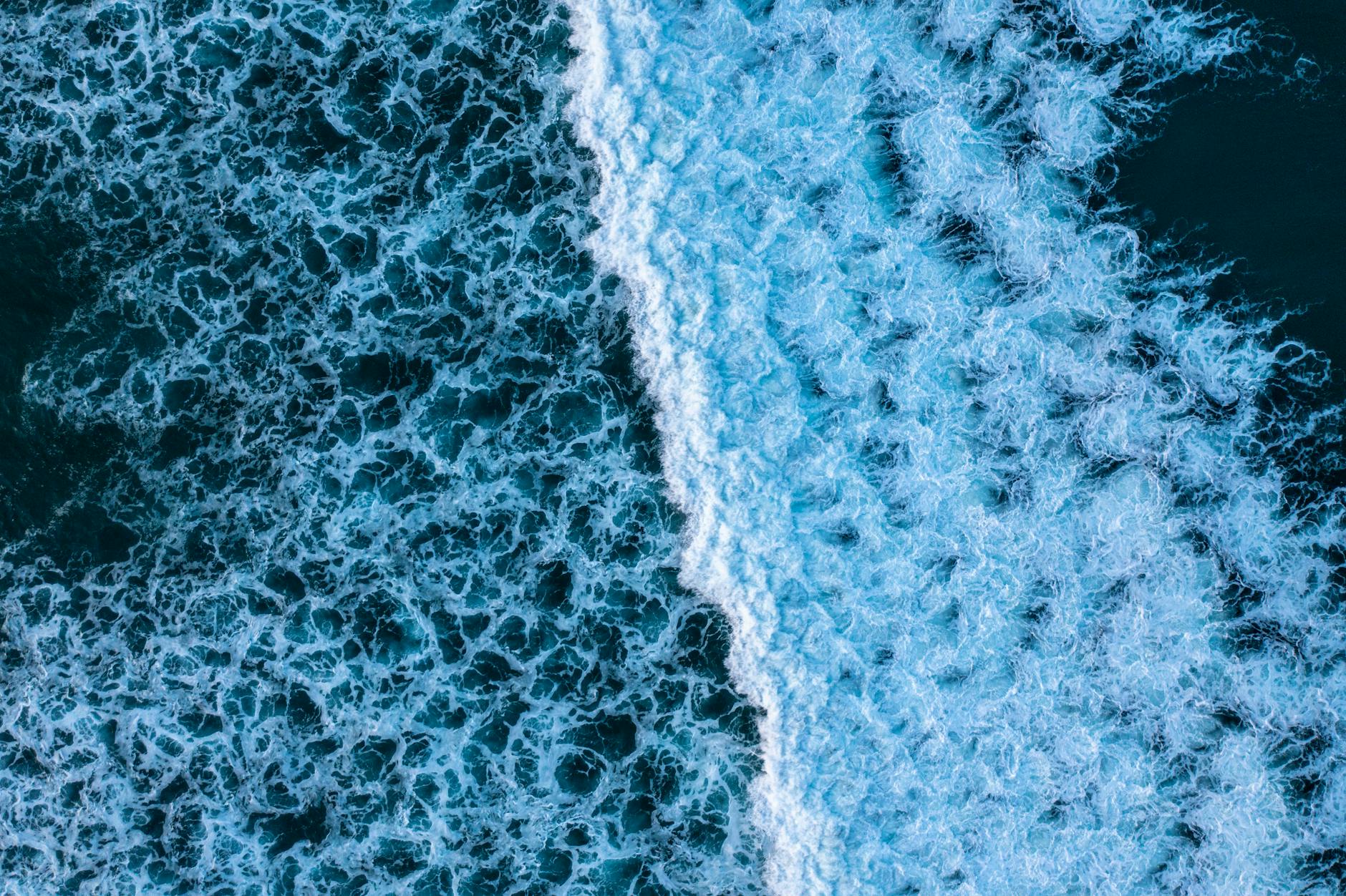 Dramatic aerial photo capturing the foamy waves of the ocean in Australia, showcasing nature's dynamic patterns.