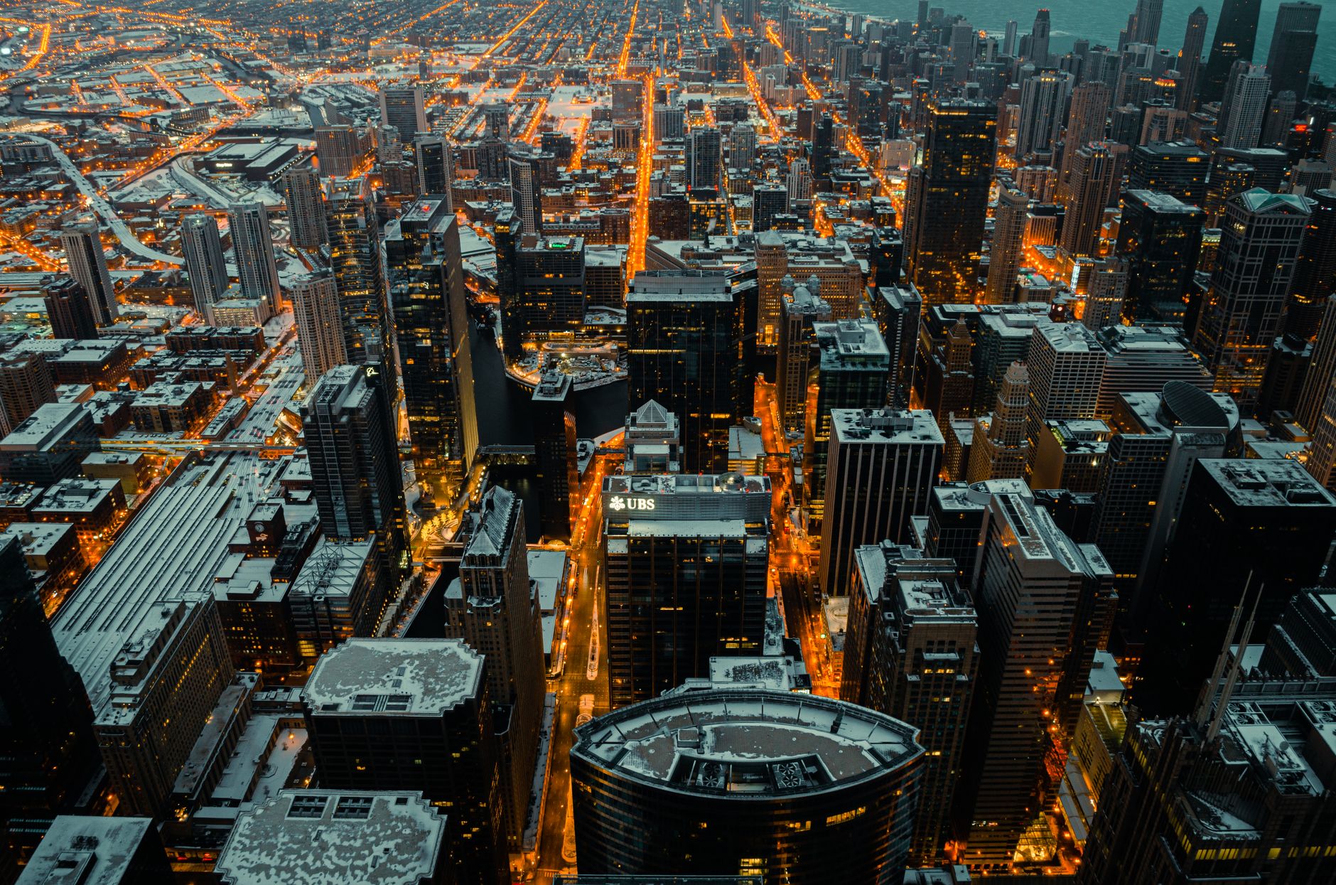 Stunning aerial view of Chicago's illuminated skyline dusted with snow at twilight.