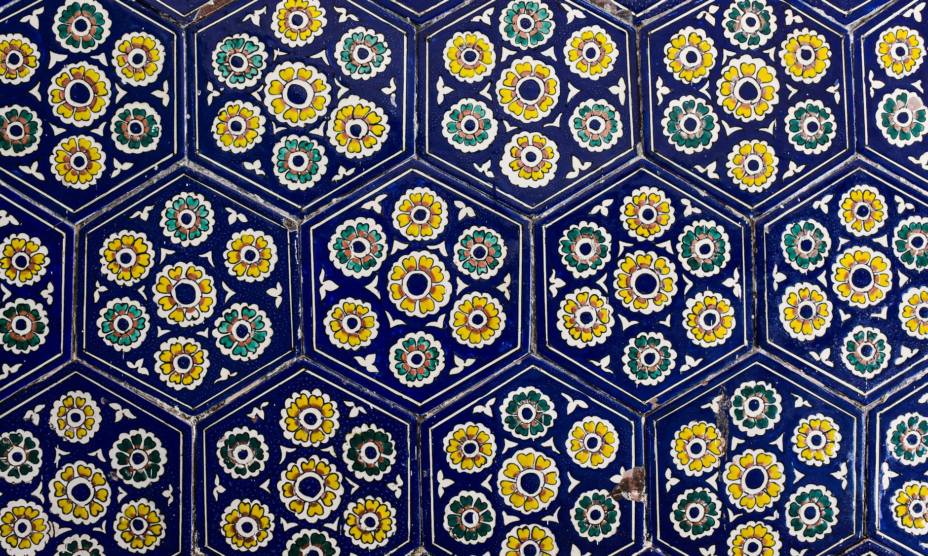 Close-up of colorful floral mosaic tiles in a hexagonal pattern, showcasing intricate designs.